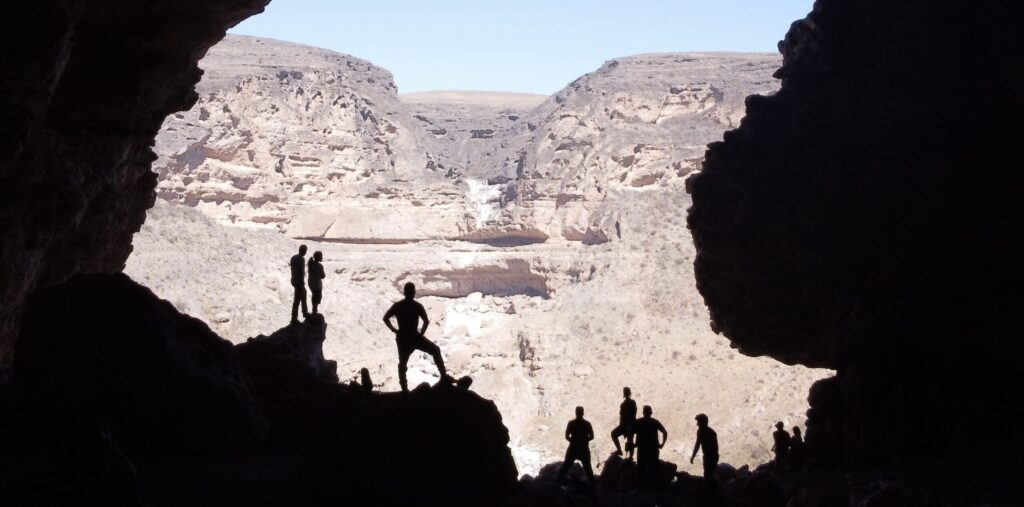 Hiking Teeq Cave in Salalah Oman with natural cave opening and mountain landscape