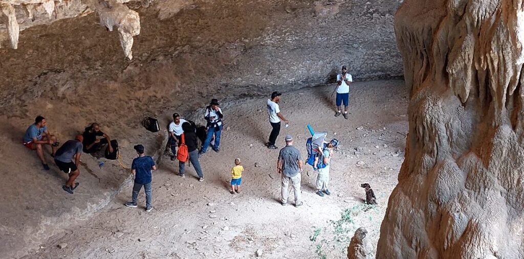 Group of hikers exploring Bat Cave in Nujab Valley Salalah Oman during guided hiking adventure tour